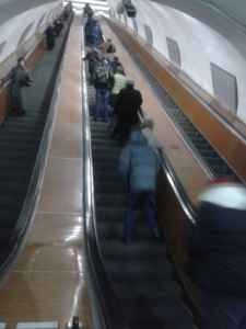 "ესკალატორზე მაღლა მიმავალ მწვანექურთუკიან ქალბატონს და მის გვერდით მდგარ მაღალ ბიჭს დააკვირდით!"